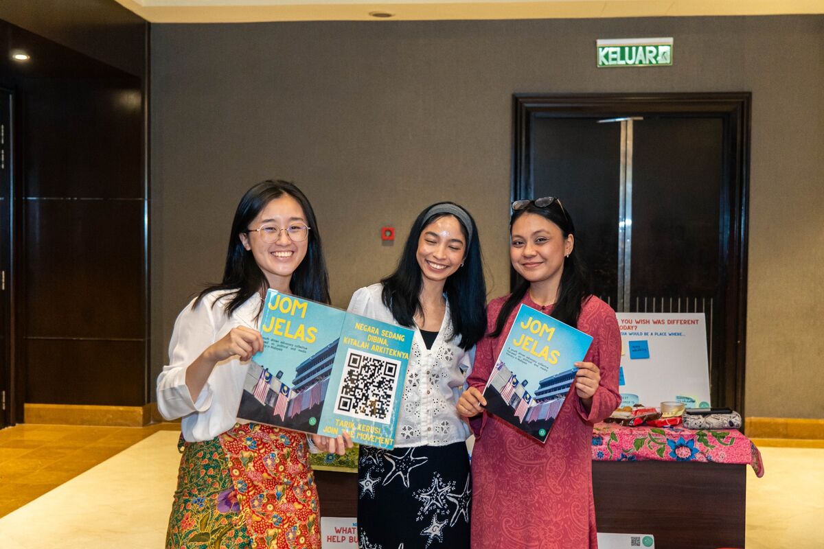 Three Jom Jelas organisers holding zines at the MSLS booth