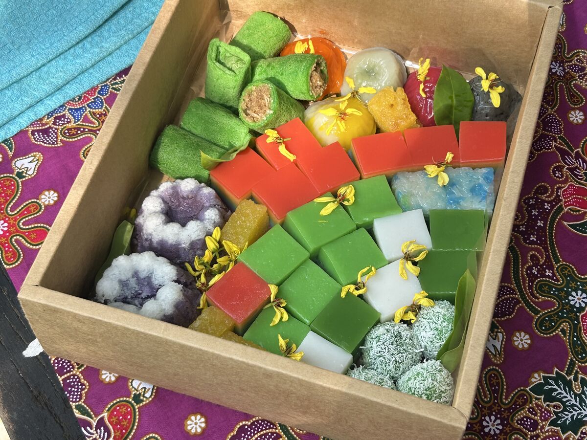 A box of kuih laid out on a batik cloth